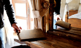 A picture of a man keeping his Blackbrook leather sleeve on a wooden table.