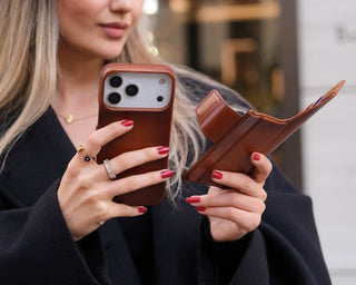 A picture of a woman holding an iPhone 17 Pro with BlackBrook’s Burkley Wallet Case.