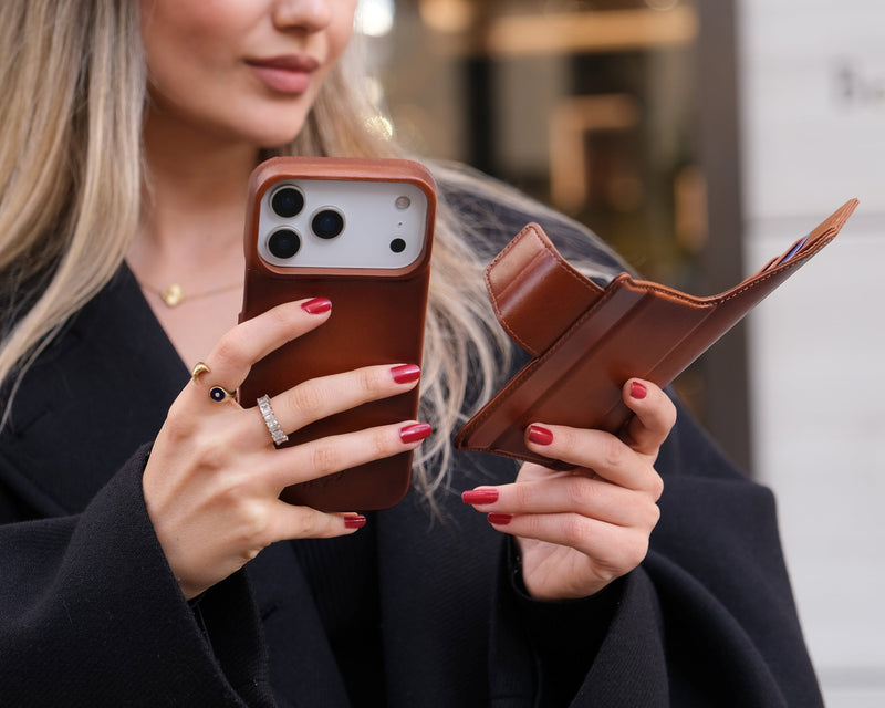A picture of a woman holding an iPhone 17 Pro with BlackBrook’s Burkley Wallet Case.