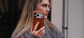  A picture of a woman holding an iPhone 17 Pro with a Blackbrook’s Leather Snap-On Case.