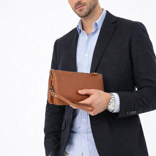Man holding a brown leather clutch against a white background